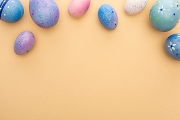 Top view of purple chicken eggs on beige background
