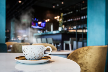 ceramic Cup with hot tea or coffee on a table in a cafe or restaurant