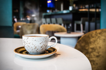 Cup with hot tea or coffee on a table in a cafe or restaurant