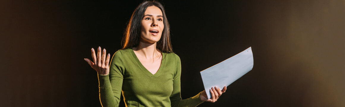 Panoramic Shot Of Attractive Young Actress Reading Scenario On Black