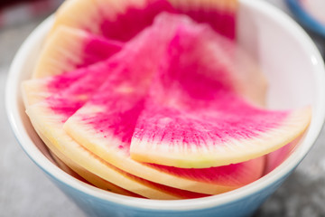 close up view of fresh watermelon radish slices in bowl