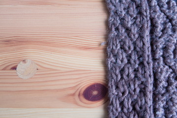 Designer background made of wood and knitted brown scarf. Texture