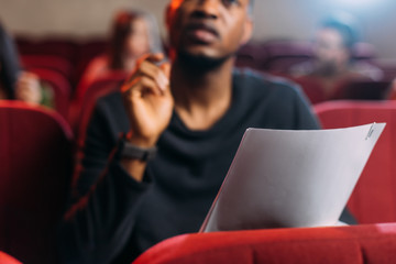 selective focus of multicultural young actor and actresses reading scripts in theater
