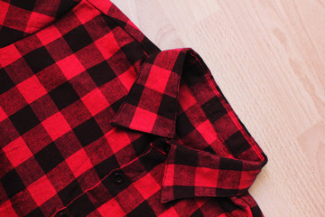 Red plaid shirt texture, tartan scottish pattern clothes. Flannel casual squared jacket, close up top view of red and black color button-up shirt 