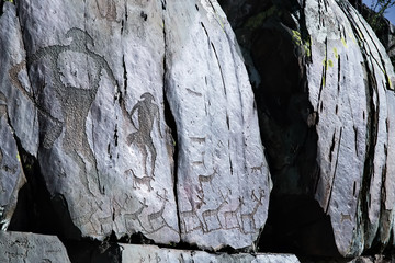 Petroglyphs on the rock. Ancient drawings on the stone.