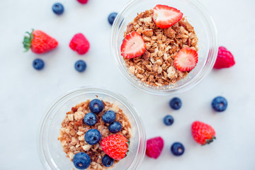 Oatmeal porridge in bowl topped with fresh blueberries, cranberries and homemade crunchy granola