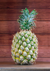 Ripe pineapples on a grey wooden background.