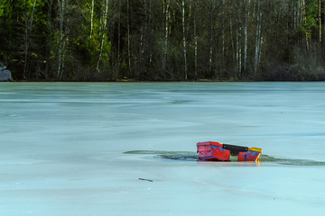 Czerwona mała łódka na lodzie pośrodku zamarzniętego jeziora