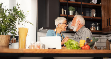 Happy couple looking each other in kitchen