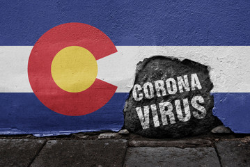 Flag of Colorado on the wall with cracked stone with text Coronavirus on it. 2019 - 2020 Novel Coronavirus (2019-nCoV) concept, for an outbreak occurs in the state of Colorado.