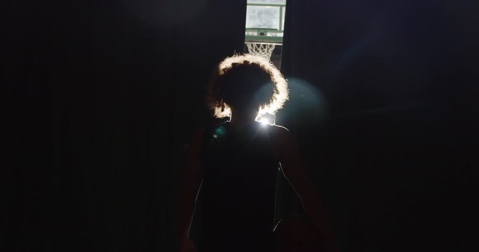 Young guy curly basketball player darkness silhouette getting ready light beam image serious shadow parquet hall sports gym