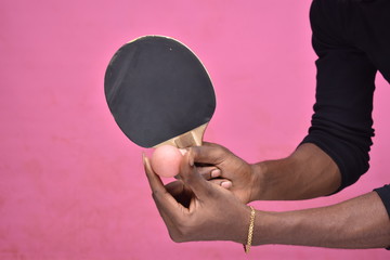 handsome young black man holding a table tennis ball in hand ready to serve