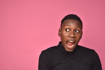 handsome young black man looking surprised and excited