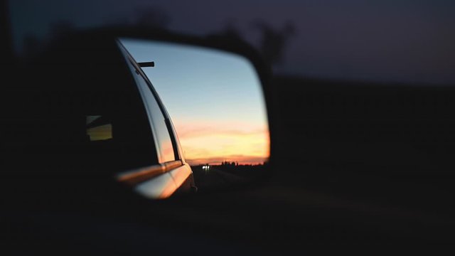 sunset reflected in car side view mirror