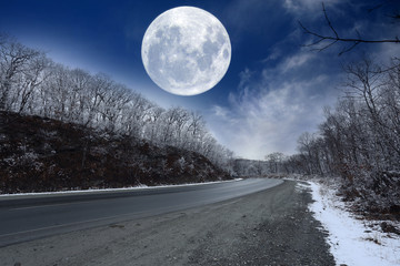 Winter road and fantastic huge Moon