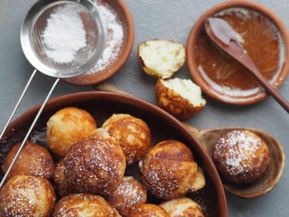 Homemade baking donuts. Deep-fried, in vegetable oil in a frying pan on a gray table. Holiday and everyday food. Place for text.