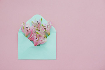 Mint envelope with a pink alstroemeria flowers inside.