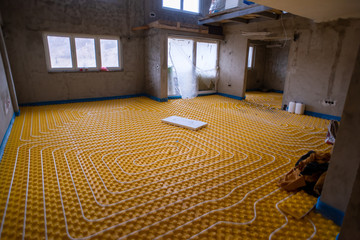 yellow underfloor heating installation with white pipes