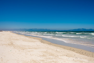 Fototapeta na wymiar White sand beach in Africa with active ocean swell