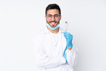 Dentist man holding tools isolated on white background laughing
