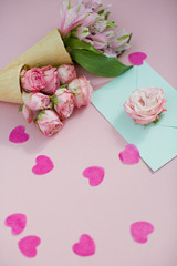 Fototapeta na wymiar Ice cream cones with pink flowers and mint envelope on pink pastel background with heart shaped confetti