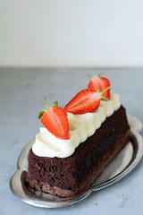 Chocolate brownie with airy vanilla cream and fresh strawberries. Chocolate cake with cream and fresh berries. Tea dessert