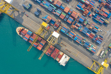 Container ship in export and import business and logistics. Shipping cargo to harbor by crane. Water transport International. Aerial view and top view.