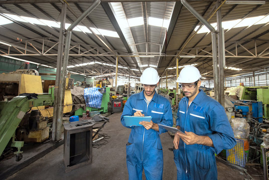 Industrial engineers are talking. They work at the heavy Industry manufacturing facility.