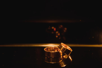 Beautiful wedding golden rings on dark background