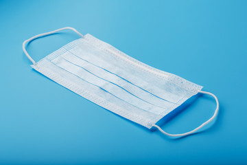 Medical mask on a blue background. Disposable face masks for viruses. Free space.