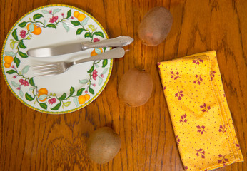 Tres kiwis y varios limones sobre una mesa de madera