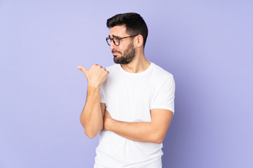 Caucasian handsome man over isolated background unhappy and pointing to the side