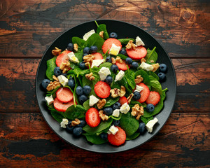 Spinach, Strawberry, blueberry salad with walnut and feta cheese. Summer healthy food