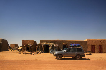 samochód terenowy przejeżdżający przez afrykańską wioskę
