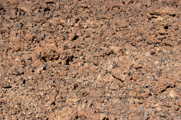 Rough volcanic soil at the foot of the Teide volcano. Nature texture of the lava surface.
