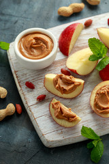 Peanut butter and apple to snack. on white wooden board