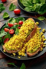 Scrambled Tofu crispy Toast with guacamole and spinach, tomato salad. Vegan vegetarian, plant based food