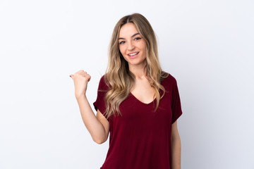 Fototapeta premium Young woman over isolated white background pointing to the side to present a product