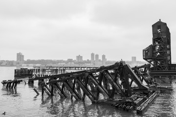 Fototapeta na wymiar Black and White Photo of the Ruins of the 69th Street Transfer Bridge in the Hudson River of New York City on a Foggy Day