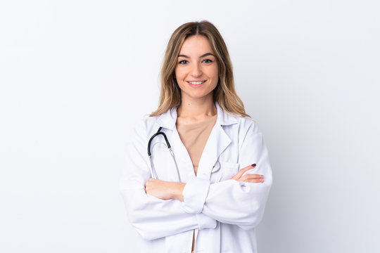 Young woman over isolated white background wearing a doctor gown and with arms crossed