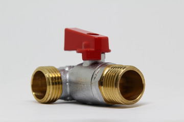 Brass ball valve with red handle on white background.