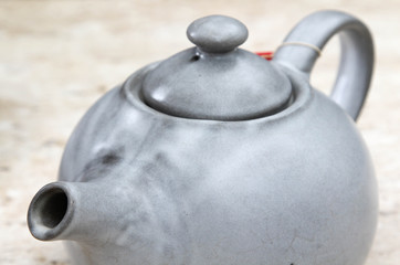 Gray ceramic chinese teapot closeup.