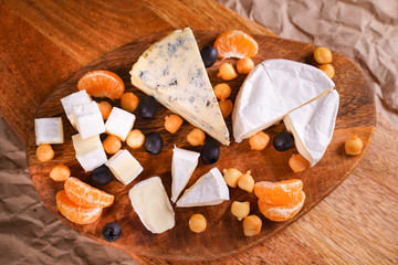 view from top Assorted cheeses on a wooden Board 
