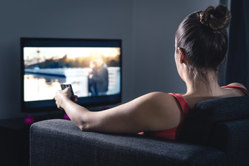 Woman streaming movie or watching series. Person using smart tv remote control to choose film or...