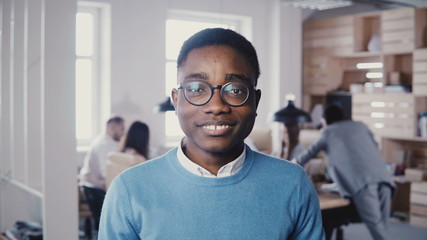 Handsome young African American businessman in glasses smiling at camera. Hipster stylish male...