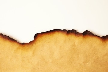 Part of a scroll of old paper with burnt edges closeup on a white background