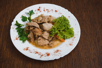 Plate of grilled beef nuggets, fried potato chips or French fries and fresh leafy green salad with cucumber on a white background