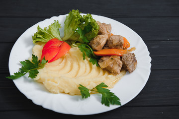 mashed potatoes with meat and vegetables on wooden background