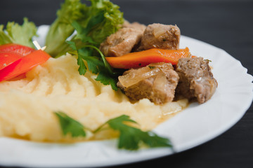 mashed potatoes with meat and vegetables on wooden background
