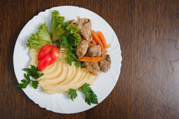 mashed potatoes with meat and vegetables on wooden background